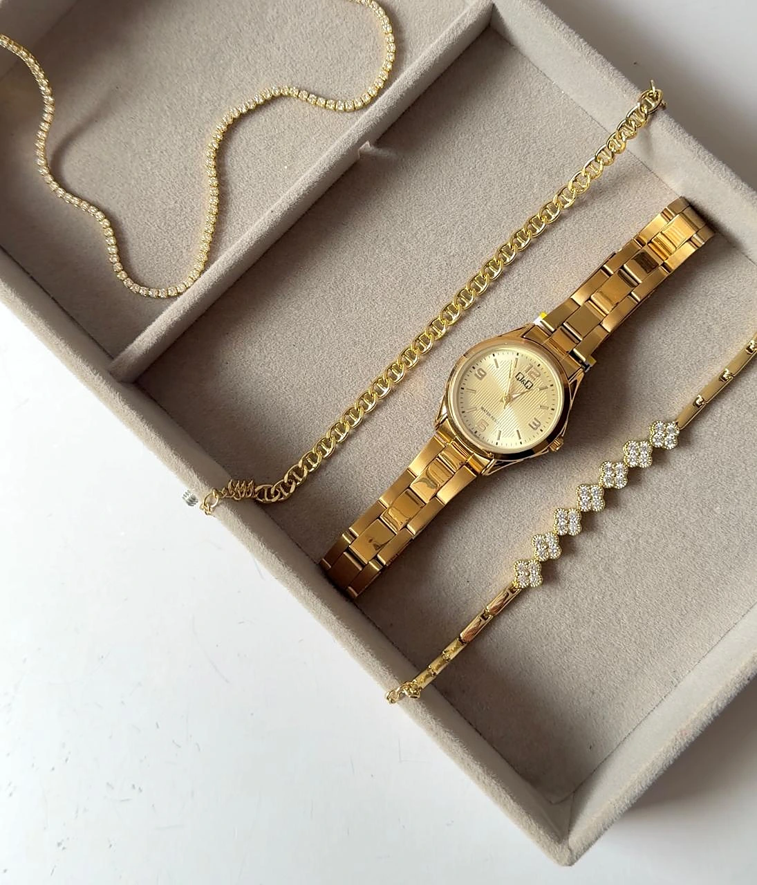Reloj dorado con cadena y pulseras de Verde Menta